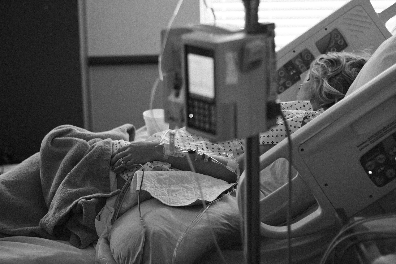 Patient in bed in ICU with monitors.
